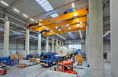 Zweiträgerlaufkran in Tandemsteuerung beim Entladen des LKWs